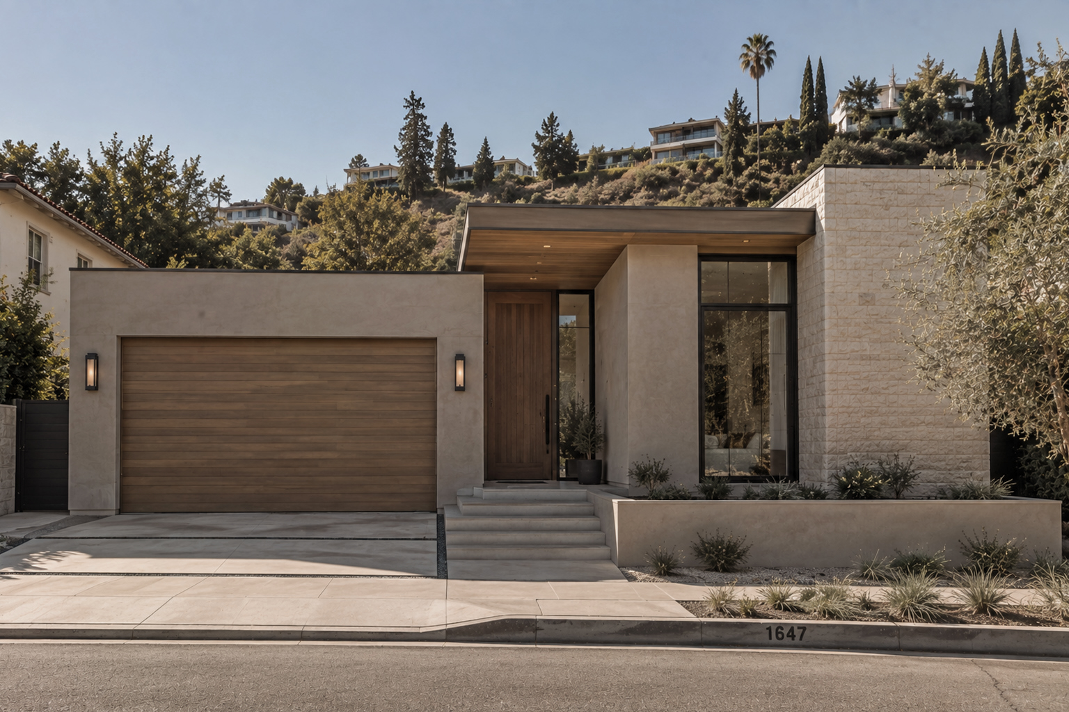 Contemporary Hollywood Hills residence with limestone facade, wood-paneled garage door, and hillside homes beyond